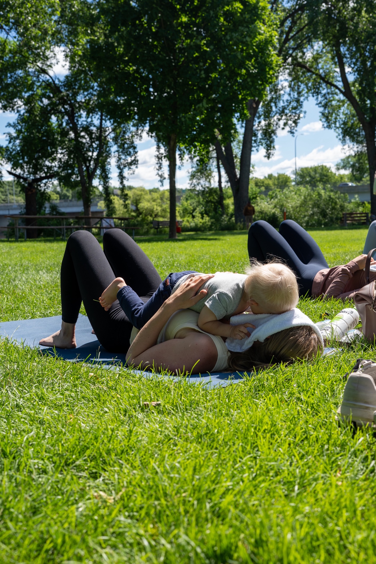 Mom and baby enjoying outdoor Pilates by the river at the Mommy and Me event